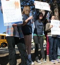 Ninth grader Emily Ladnier tells passing cars to “Honk for Education” during a Stand Up for Schools rally last Thursday at Mira Costa High School. The rally was intended to raise awareness about education cuts in state funding. Photo by Andrea Ruse